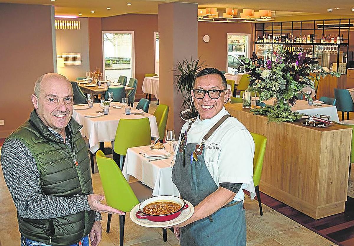 Ángel Ibarlucea, junto a un camarero, muestra una de las múltiples creaciones del Ikuspegi en su acogedor comedor.
