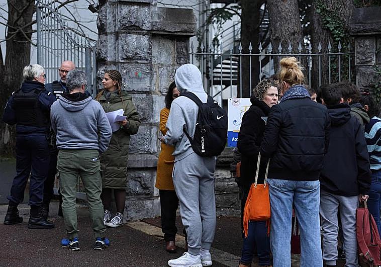 Alumnos, padres y periodistas, frente a la puerta del liceo.