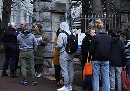 Alumnos, padres y periodistas, frente a la puerta del liceo.
