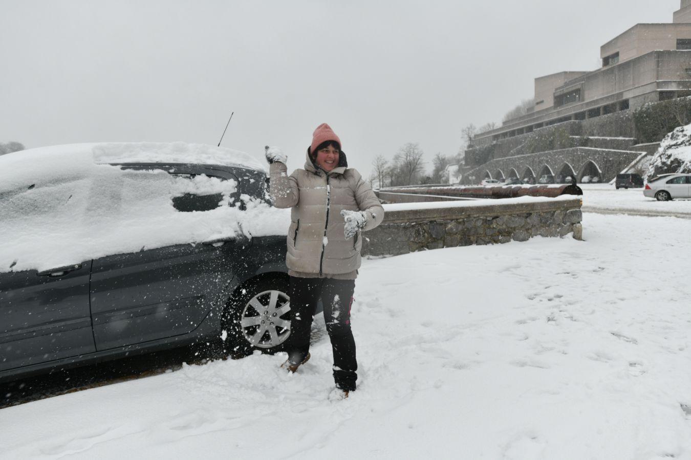 Una mujer juega con la nieve.