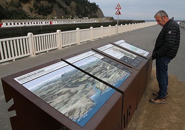 Detalles. Un hombre contempla unos paneles junto a la ría.