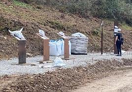 Tótems en el camino. Una caminante observa algunos de los elementos de la ruta.