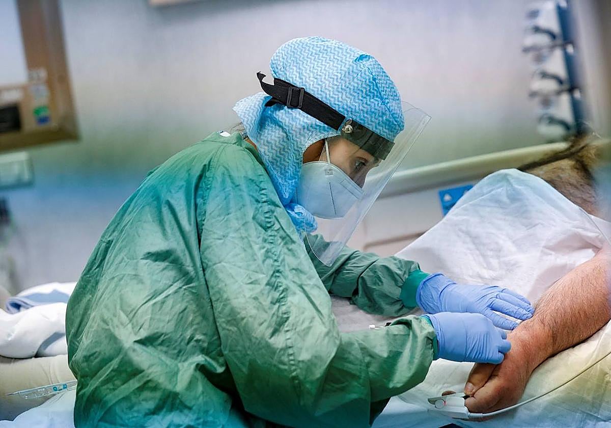 Una sanitara atiende a un paciente con coronavirus.