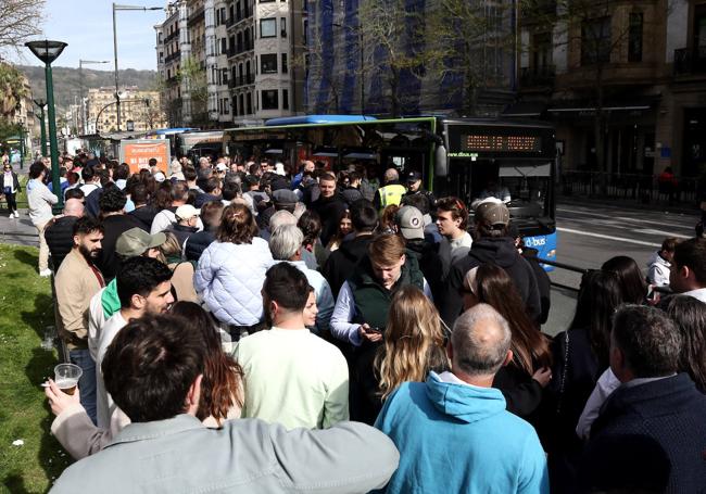 Cientos de aficionados esperan un autobús en el Boulevard de Donostia.