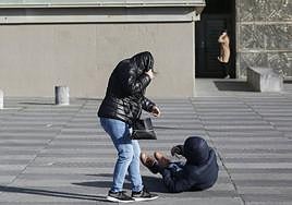 Un hombre cae al suelo en el Kursaal por una fuerte racha de viento este domingo por la tarde.