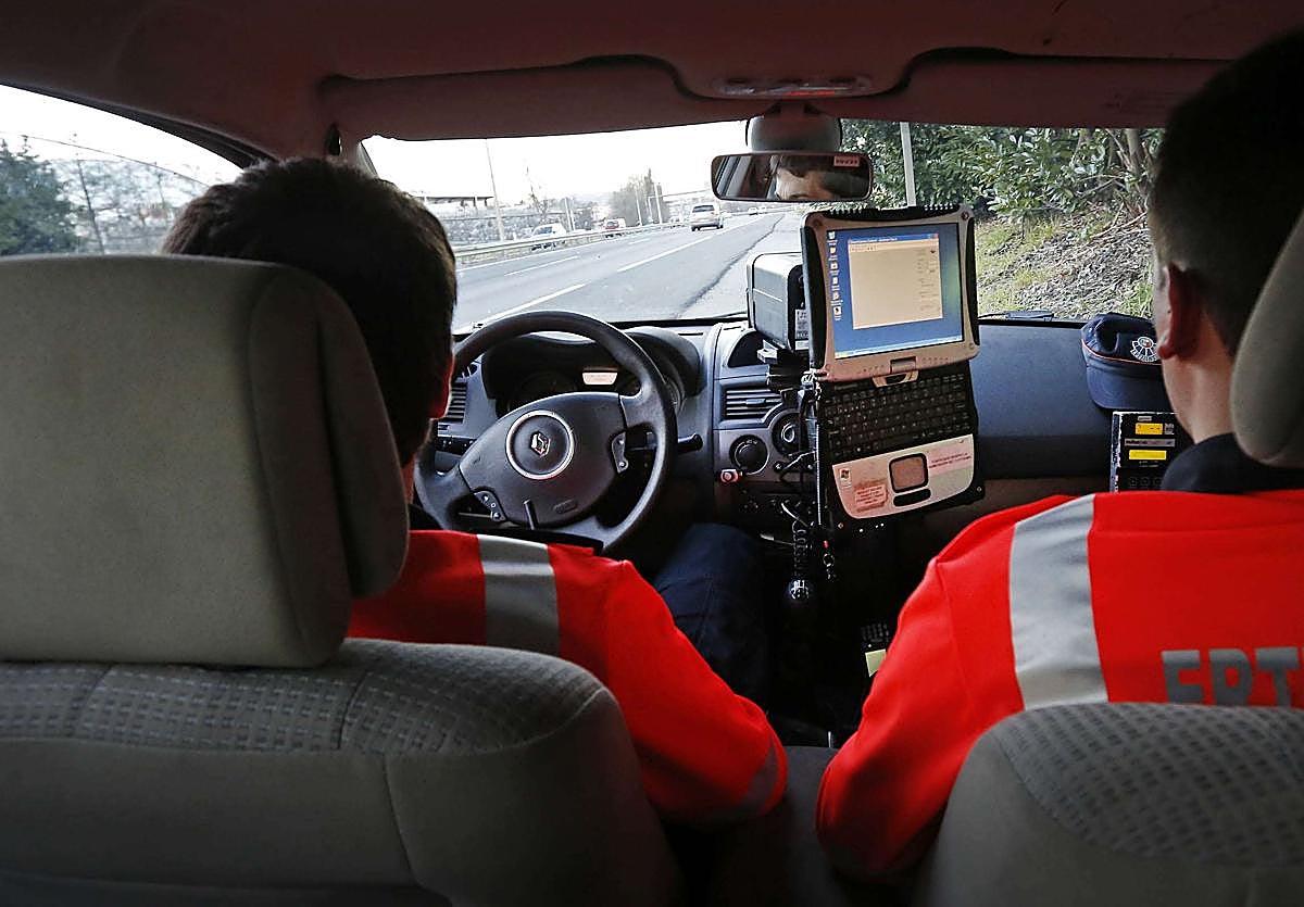 Una pareja de la Ertzaintza con un radar móvil en una carretera guipuzcoana.