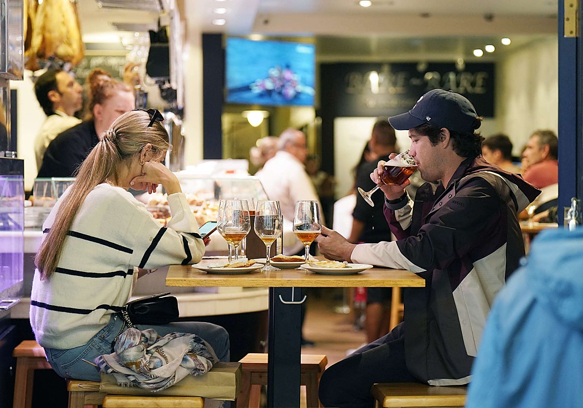 Una pareja disfruta de unos pintxos en un bar de la Parte Vieja de San Sebastián.