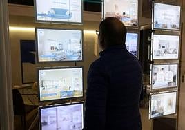 Un hombre observa la oferta de viviendas en el escaparate de una agencia inmobiliaria de San Sebastián.