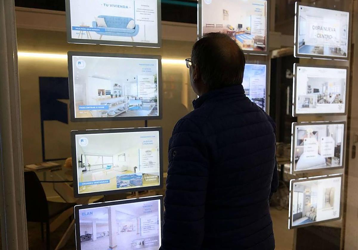 Un hombre observa la oferta de viviendas en el escaparate de una agencia inmobiliaria de San Sebastián.