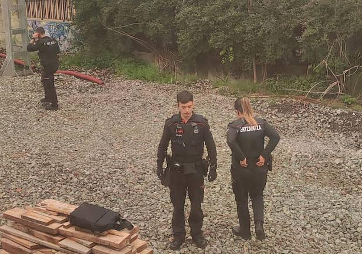 Varios ertzainas se acercan al tren, parado frente a las casas del paseo de Francia.