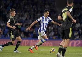 Merino conduce un balón perseguido por Kroos en el centro del campo.