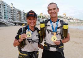 Ya en casa. Nerea y Cristóbal lucen en la playa de La Concha las medallas que acreditan que han finalizado el Maratón del Sables.