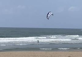 Un rider practica kitesurf sobre la playa de la Zurriola