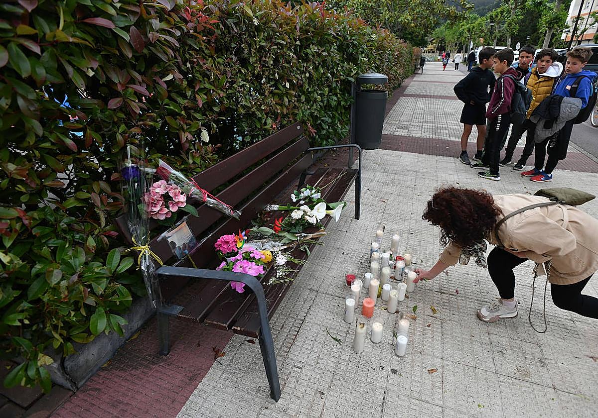 Una mujer deja una vela en el banco en el que fue asesinada Lourdes.