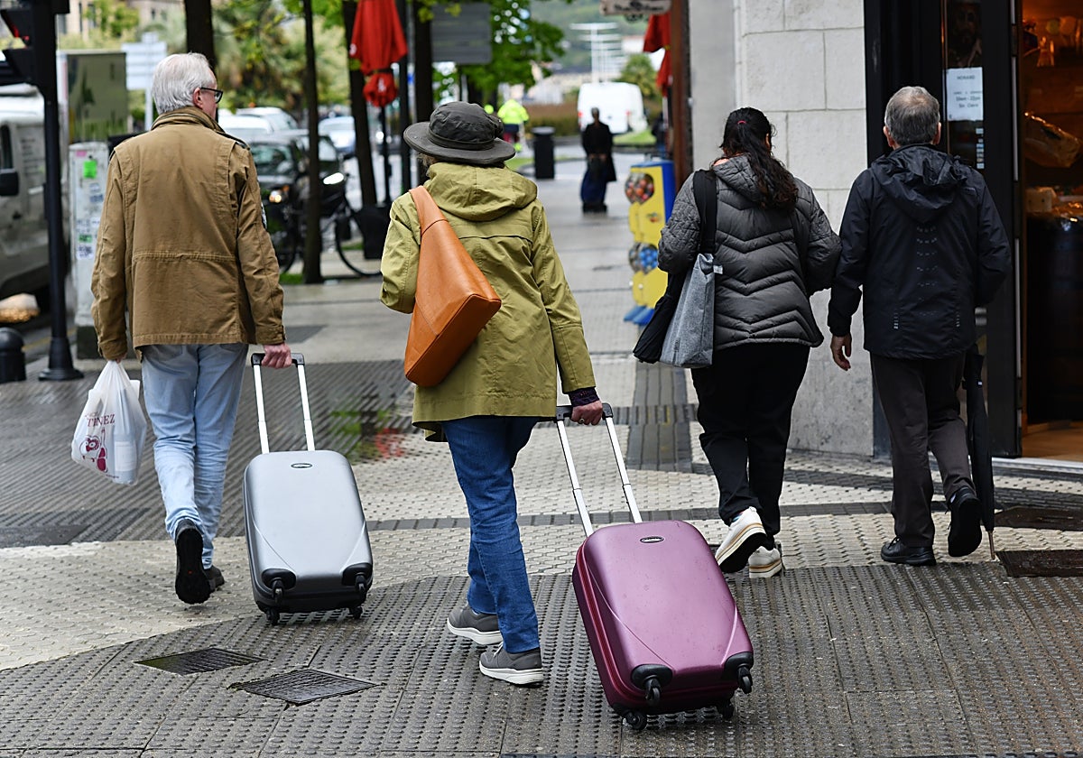 Una pareja de turistas llega a Donostia con sus maletas.