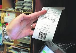 Una comerciante donostiarra emite una factura electrónica a un cliente.