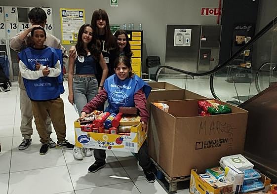 Un grupo de estudiantes recogiendo alimentos en el BM Palmera Montero.