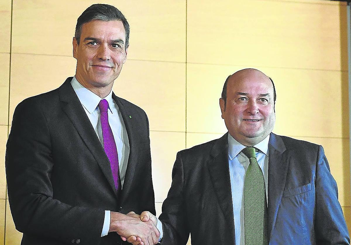 Sánchez y Ortuzar estrechan sus manos tras firmar el pacto para apoyar la investidura del líder del PSOE.