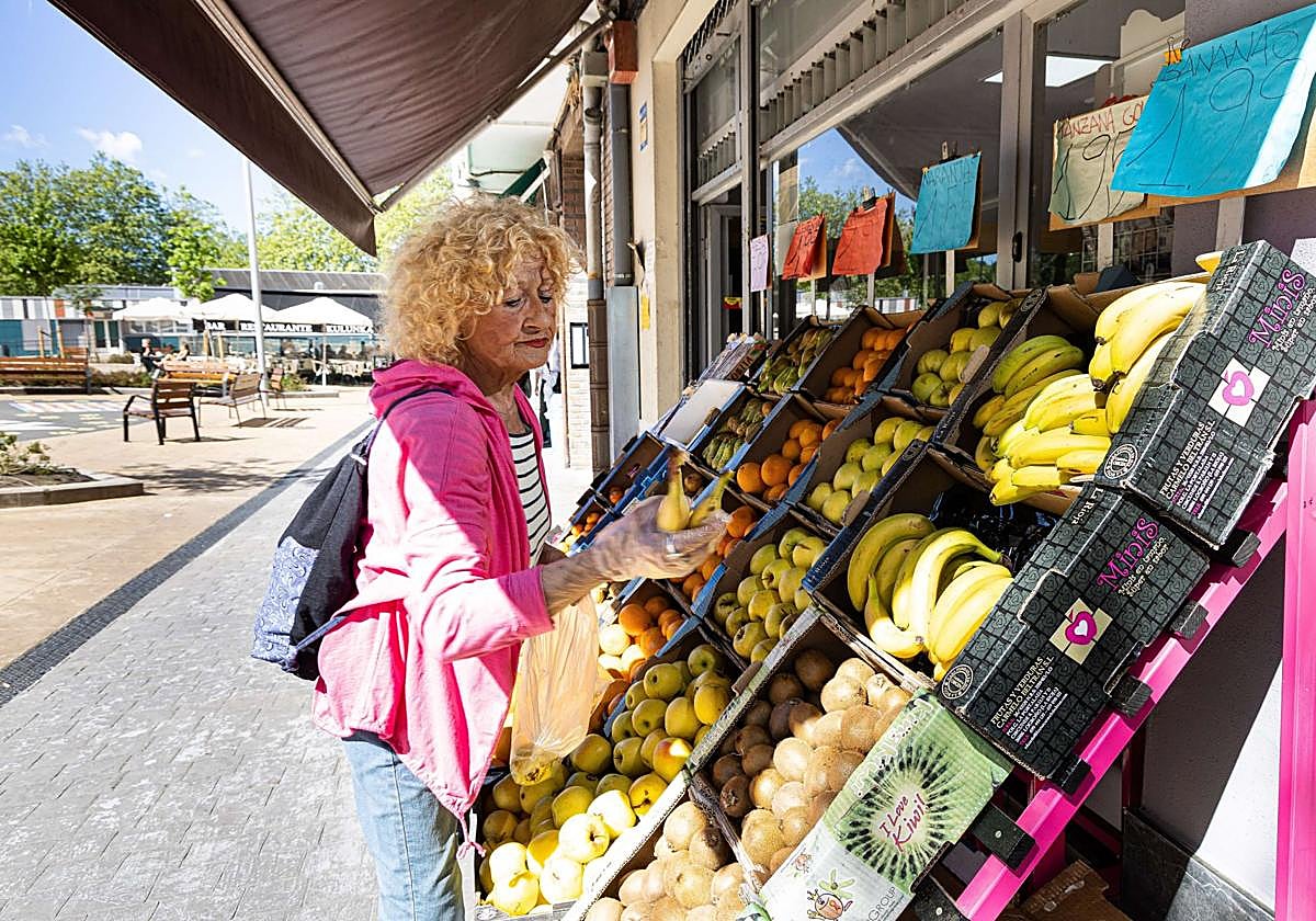 Una pensionista adquiere fruta en un establecimiento.