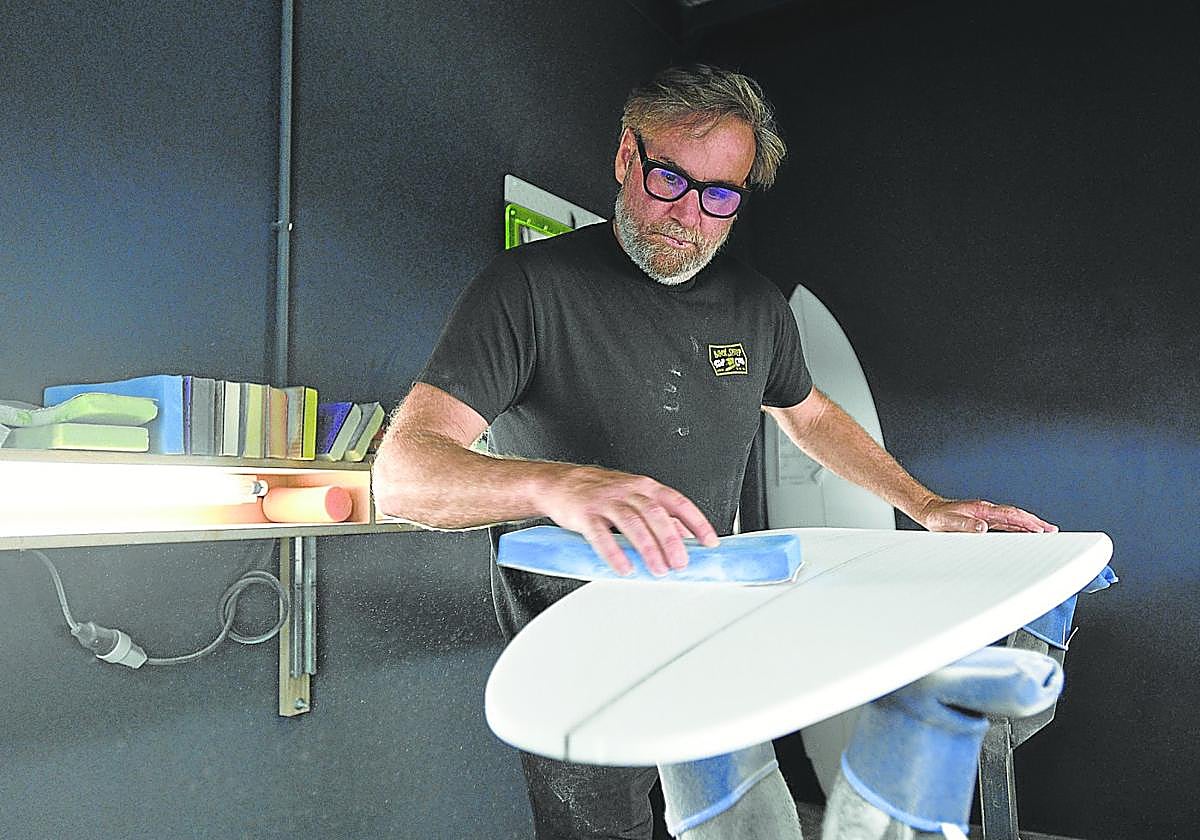 Matt Biolos lija en el 'shaper room' el núcleo de poliuretano que acabará siendo una tabla de surf.
