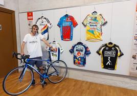 Jon Etxebeste posa junto a algunos de los maillots de la exposición.