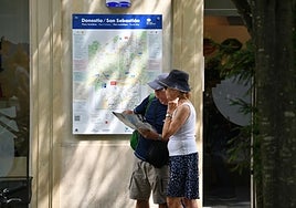 Una pareja de turistas mira un mapa en el Boulevard donostiarra.