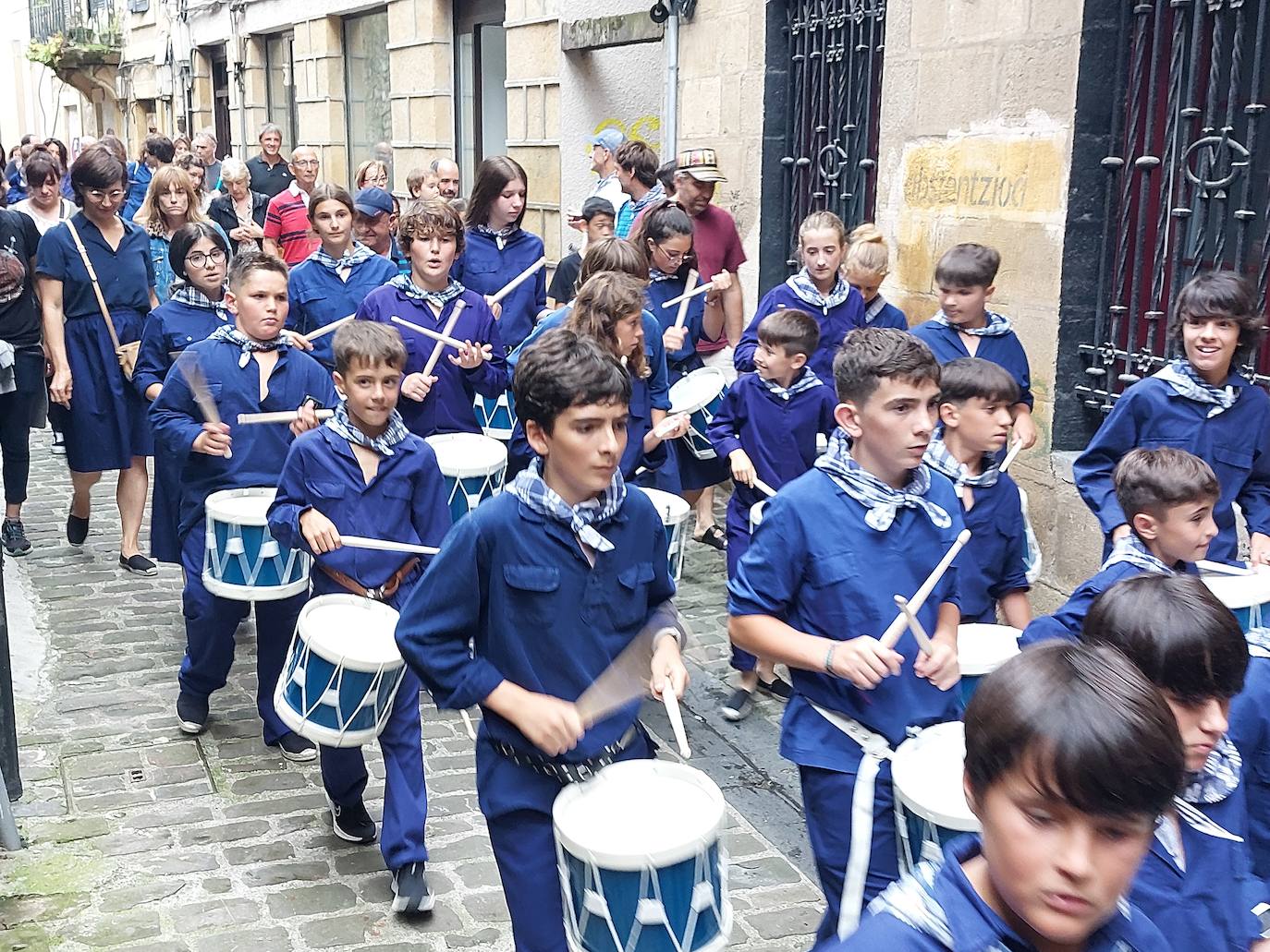 Tamborrada infantil de morado y calles multicolor