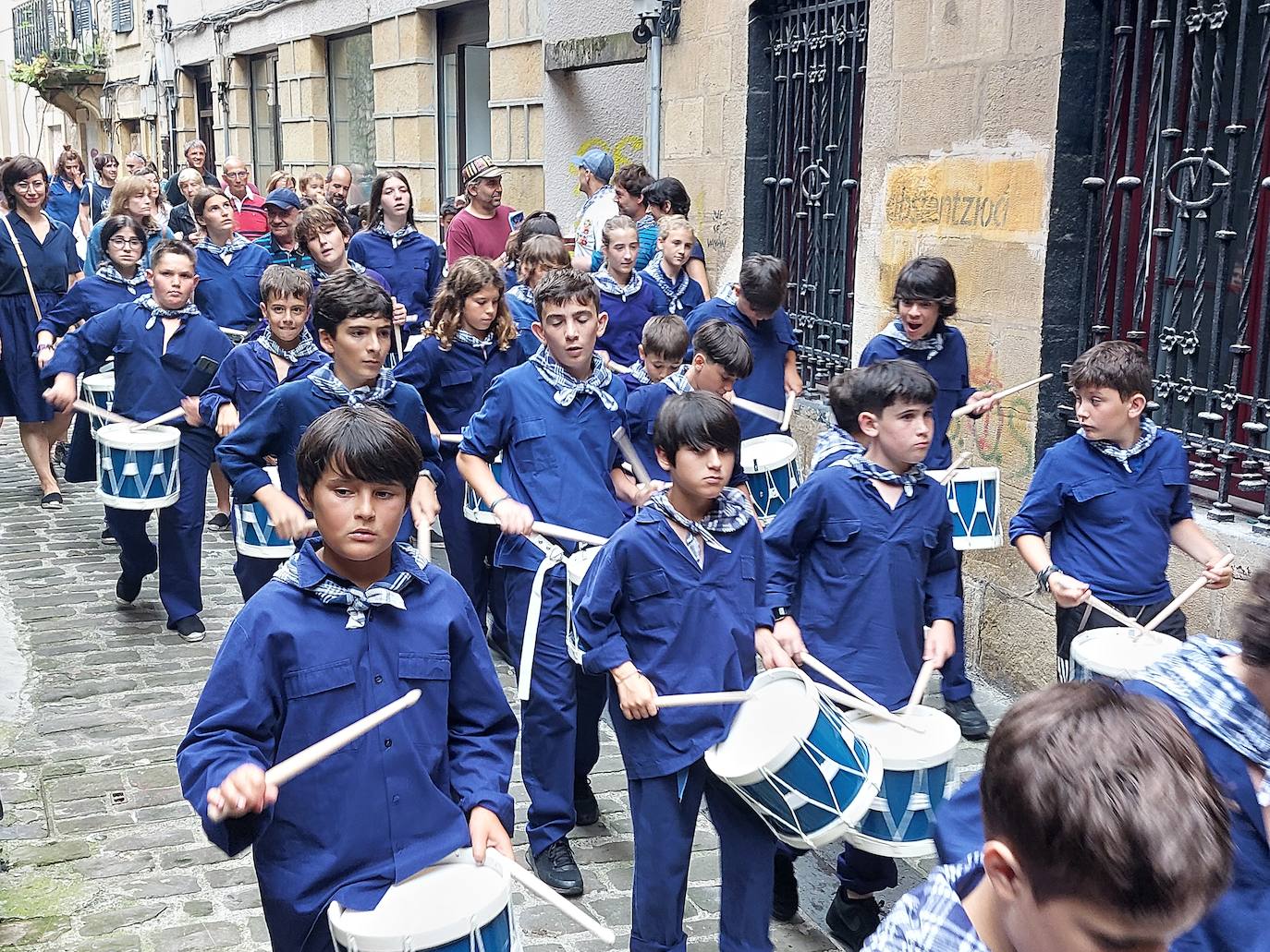 Tamborrada infantil de morado y calles multicolor