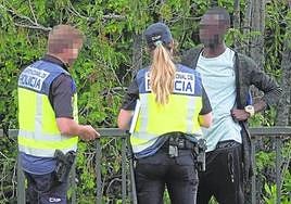 Dos policías identifican a un migrante.