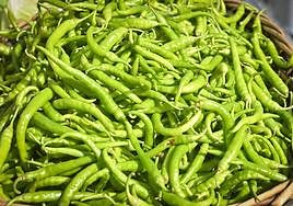 Un cesto lleno de piparras en la feria de Ibarra.