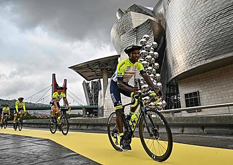 Imagen secundaria 1 - Ion Izagirre, tras Geschke, en la llegada del Cofidis a la presentación. Biniam Girmay, aspirante al triunfo en las dos primera etapas y al maillot amarillo, en Bilbao. El Ineos pasa bajo 'Mamá', la 'araña' de Louise Bourgeois en su camino a la presentación . 