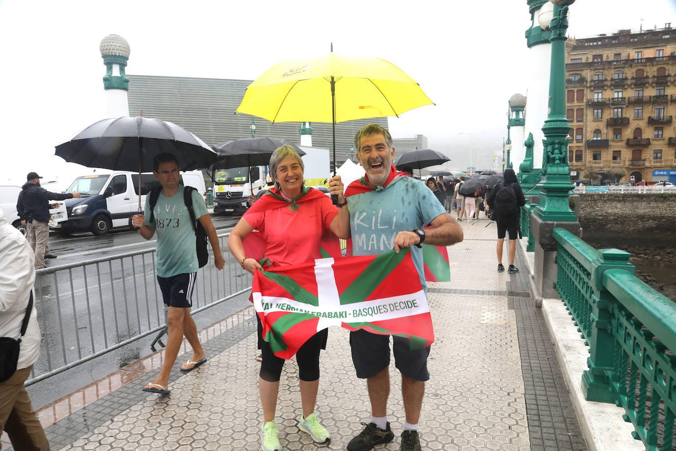 La lluvia no frena a la afición en la zona de meta en Donostia