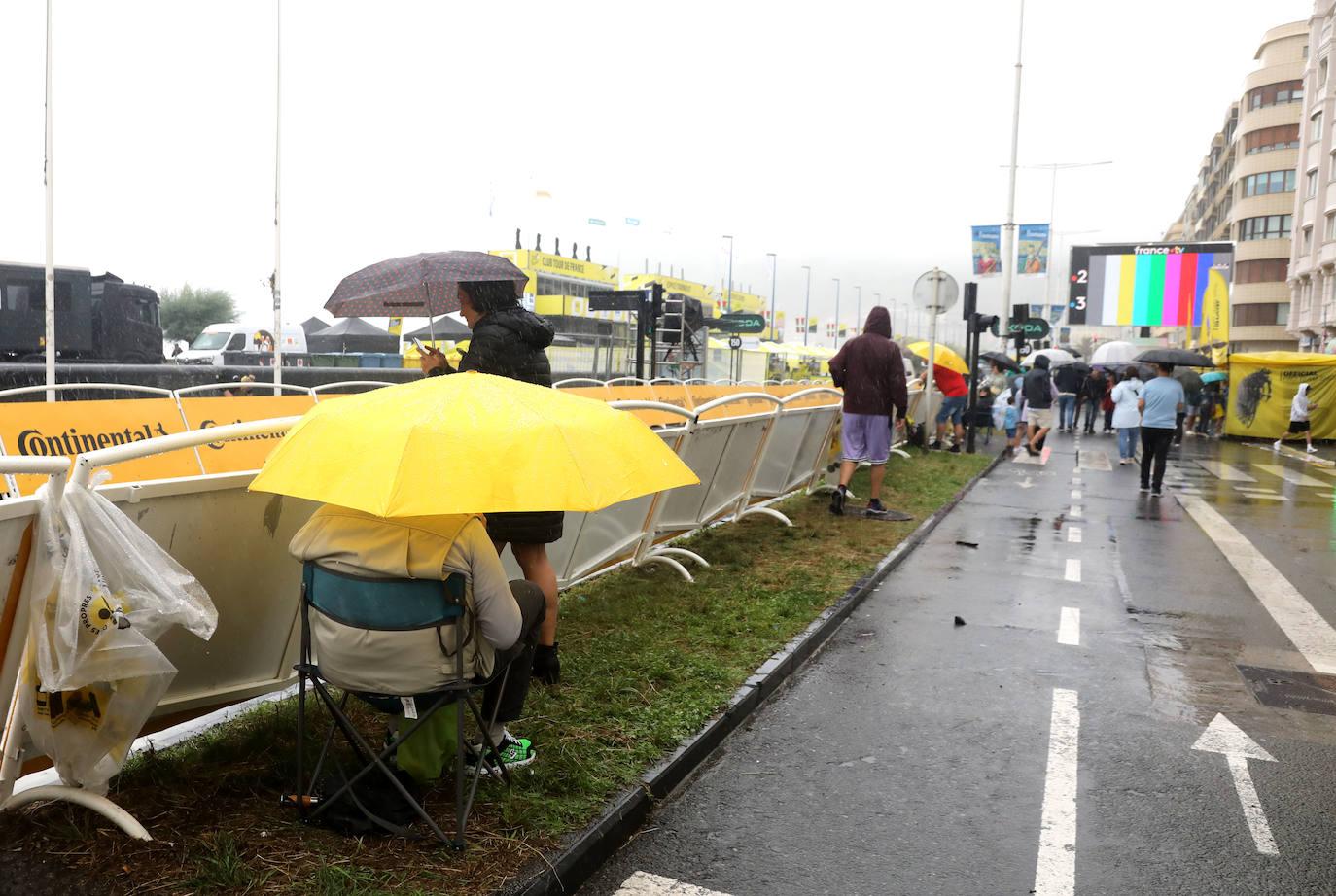 La lluvia no frena a la afición en la zona de meta en Donostia