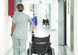 Una trabajadora del Hospital Universitario Donostia traslada una silla de ruedas.