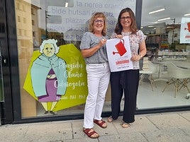 Liburutegiko ordezkariak sariketako kartelarekin.