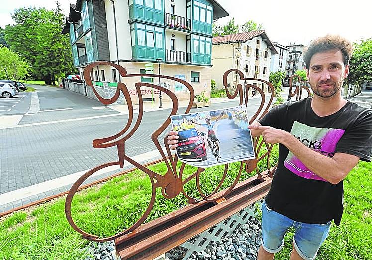 Imagen principal - Alberto señala la foto de Ion Izagirre ante la escultura que homenajea a los ciclistas guipuzcoanos. Santi y Joxe observan la foto de Ion cruzando la meta. Seguidores de Ion celebran la victoria de su vecino.