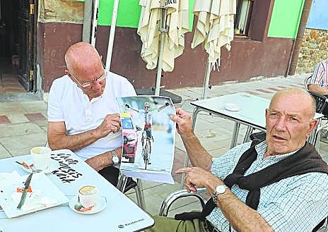 Imagen secundaria 1 - Alberto señala la foto de Ion Izagirre ante la escultura que homenajea a los ciclistas guipuzcoanos. Santi y Joxe observan la foto de Ion cruzando la meta. Seguidores de Ion celebran la victoria de su vecino.