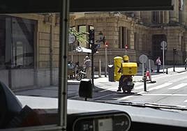Un trabajador de correos circula con su moto por Donostia