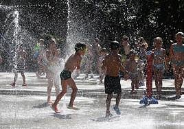 Un grupo de niños se refresca con los chorros de agua en Beasain
