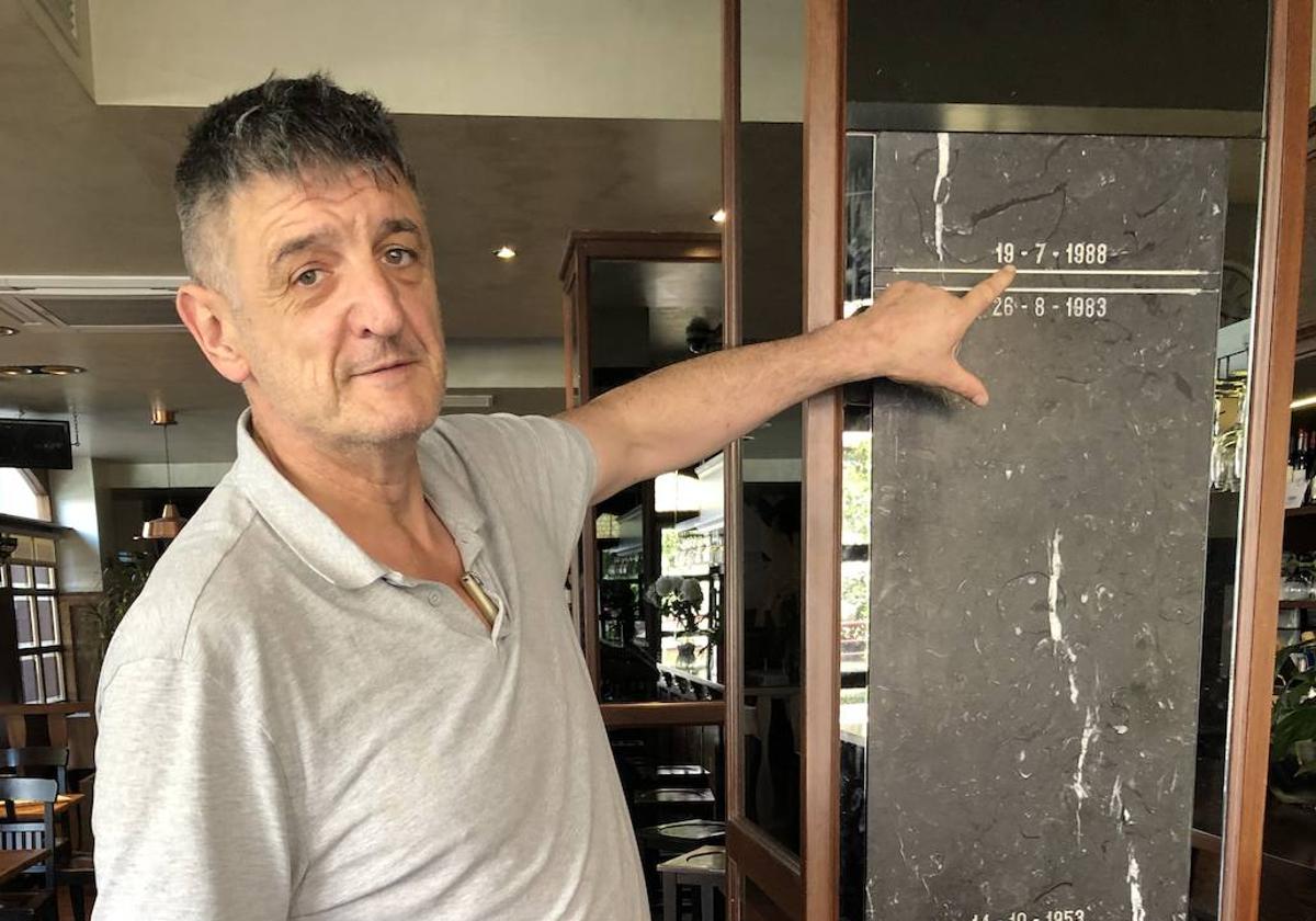 Imanol Urain, que mide 1,98m., indica el nivel que el agua alcanzó en las riadas de 1988 y 1983 en su restaurante Txarriduna de Elgoibar.