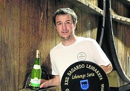 Egoitz Zapiain sostiene el caldo y la txapela obtenida en el XXII Concurso de Sidra de Gipuzkoa.