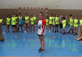 Participantes en el campus deportivo de verano practican carreras de sacos en la cancha del polideportivo.