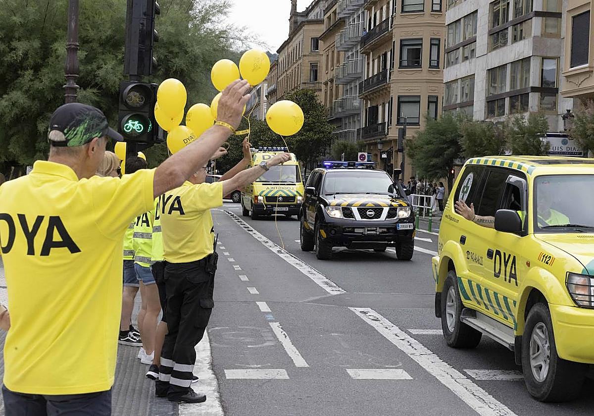 Algunos voluntarios saludan con globos al paso de los distintos vehículos de la asociación en Alderdi Eder.