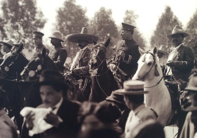 Villa, con uniforme azul y gorra de general de división, entra en Ciudad de México junto a Emiliano Zapata.