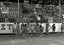 Niños ante un abigarrado puesto de tómbola.