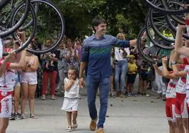 Ion Izagirre camina junto a su hija Iraia, que cumplió tres años el día de su victoria, entre el pasillo que formaron los ciclistas del Ampo en Ormaiztegi.