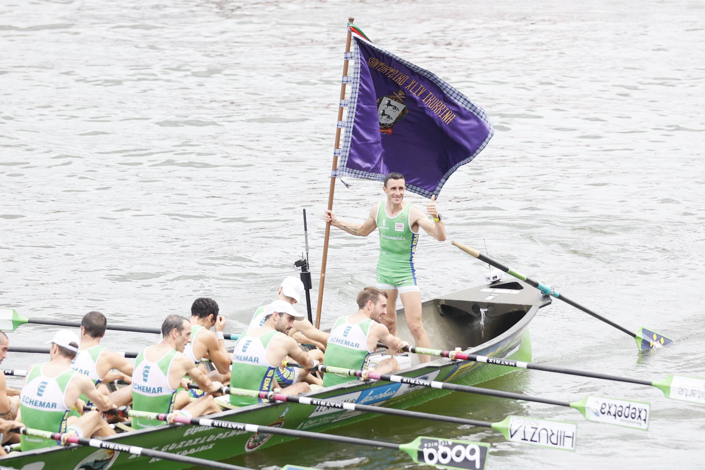 Ioseba Amunarriz porta la bandera de Santurtzi y levanta el pulgar en señal de satisfacción.