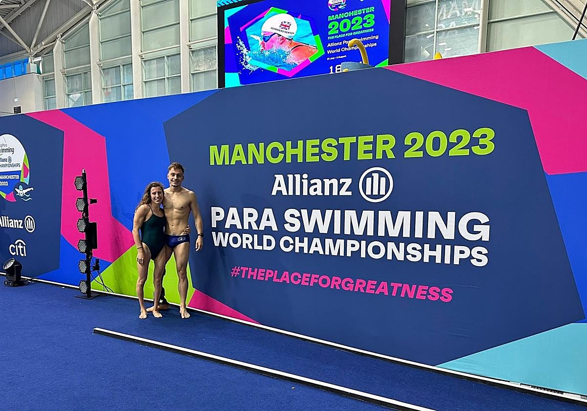 Nahia Zudaire e Iñigo Llopis, sonrientes delante del cartel anunciandor del Mundial de Manchester.