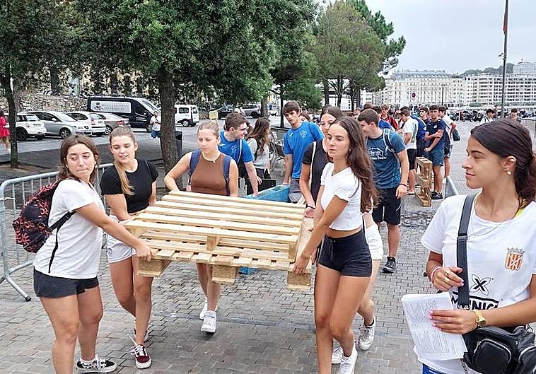 Un grupo de chicas se dirige al Muelle con el material necesario para preparar su embarcación.