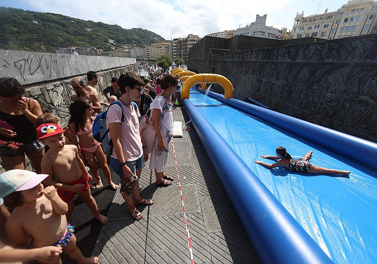 Decenas de niños esperan su turno para acceder al tobogán acuático.
